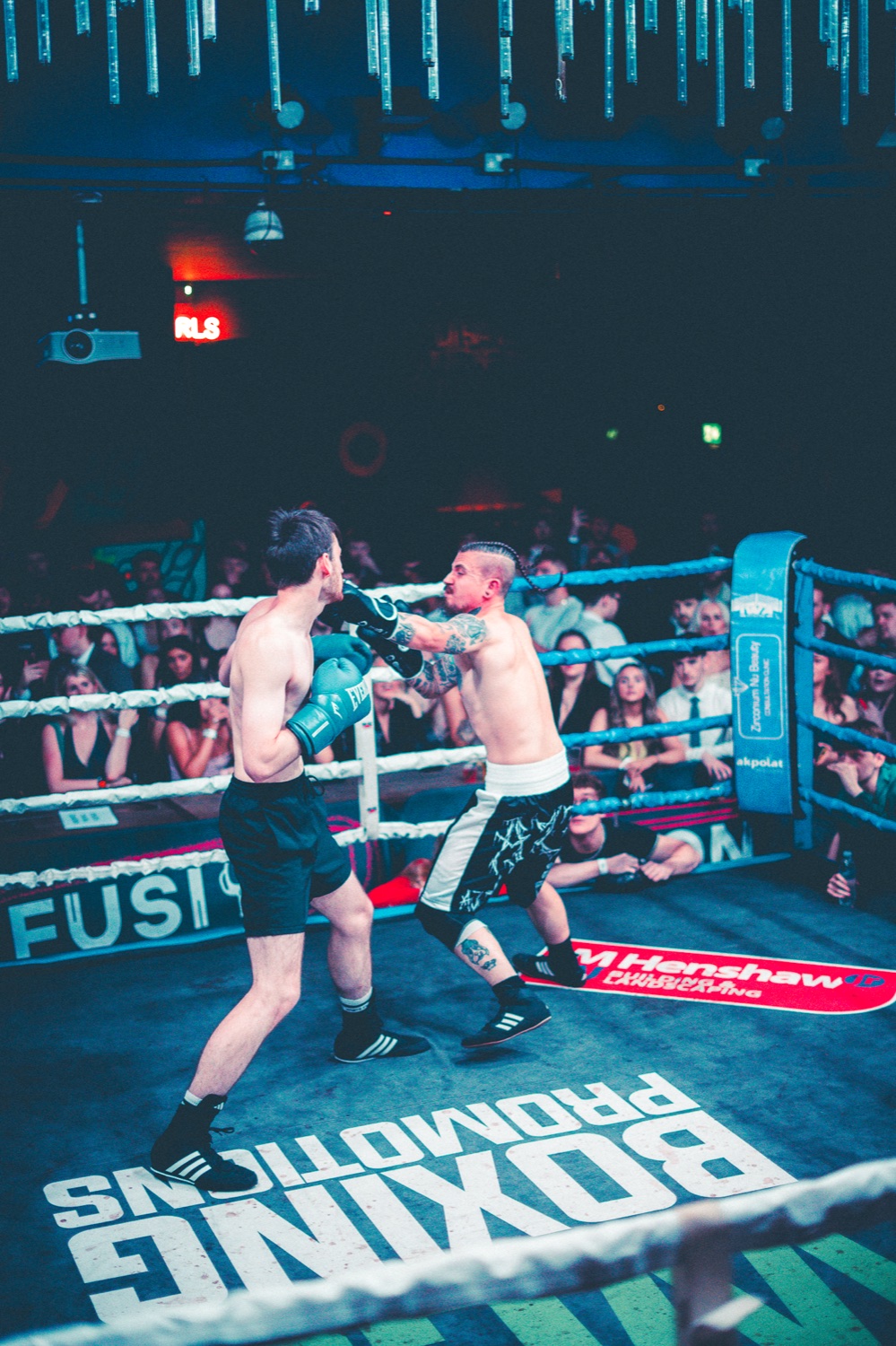 Two Industry Rumble boxers fighting under venue lights